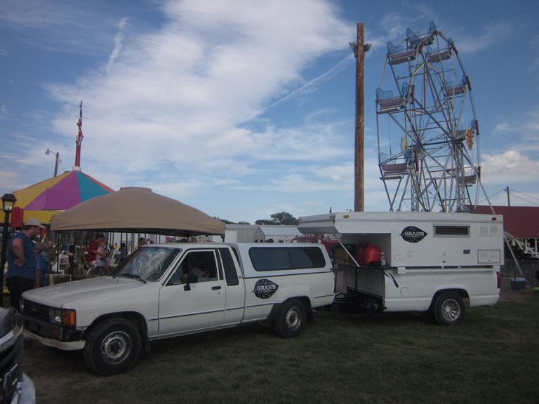 Car and camper with Gran University logo mark